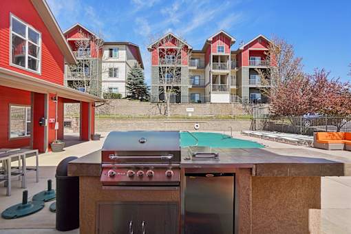 A red and white building with a pool table and a grill in front.