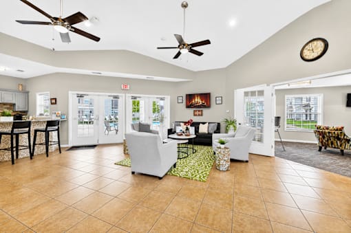 A spacious living room with a kitchen area in the background.