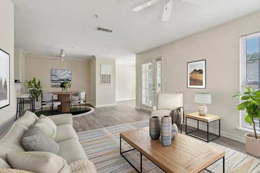 A living room with a couch, a coffee table, and a potted plant.