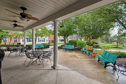 A patio with a table and chairs under a roof.