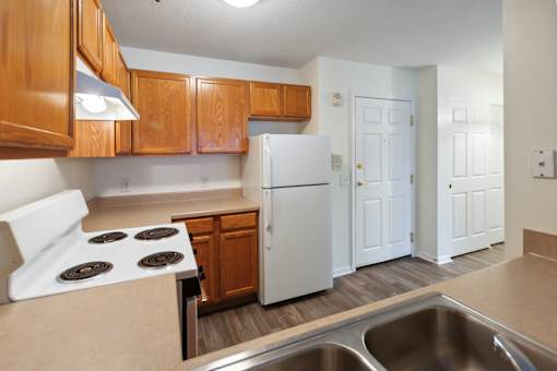 A kitchen with a white refrigerator and a white stove top oven.
