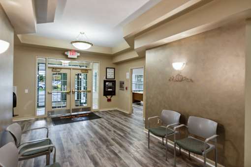 A waiting room with chairs and a wall-mounted light fixture.