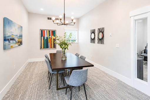 A dining room with a table and chairs.