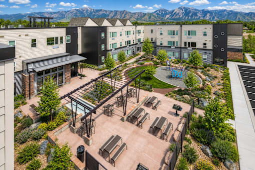 A view of a courtyard with a black metal structure and benches.
