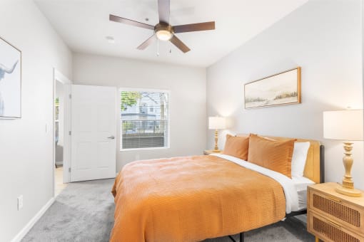 a bedroom with an orange bed and a ceiling fan