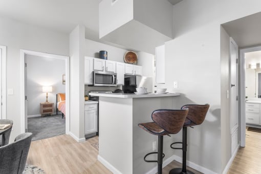 an open kitchen and living room with a bar and stools