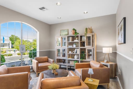 a living room with brown leather furniture and a large window