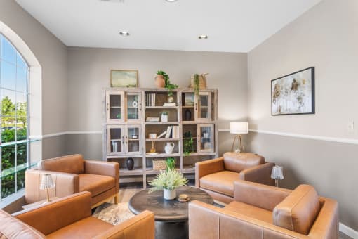 a living room with brown leather furniture and a bookshelf