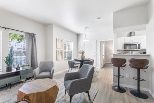a living room with a table and chairs and a kitchen