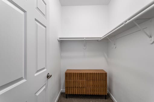 a walk in closet with a wooden crate in the middle of it