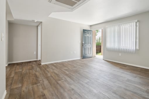 the living room and dining room of an apartment with wood flooring at Vista Linda, Santa Fe