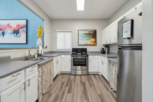 a kitchen with stainless steel appliances and white cabinets at Vista Linda, New Mexico