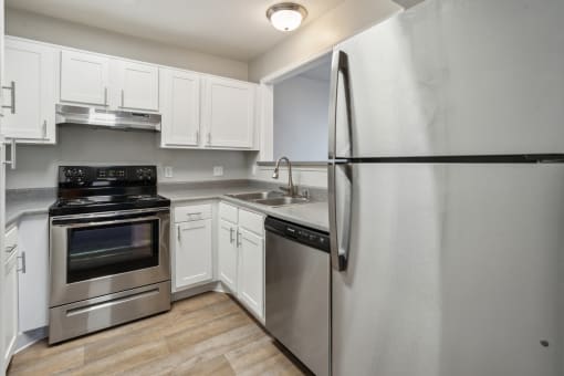 a kitchen with stainless steel appliances and white cabinets at Vista Linda, Santa Fe, NM 87507