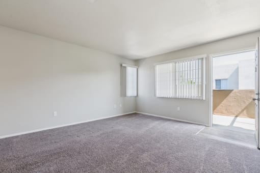the living room of an apartment with carpet and a door to the patio at Vista Linda, Santa Fe, New Mexico