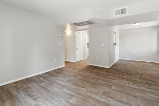 the living room and dining room in a new home with white walls and wood floors at Vista Linda, Santa Fe