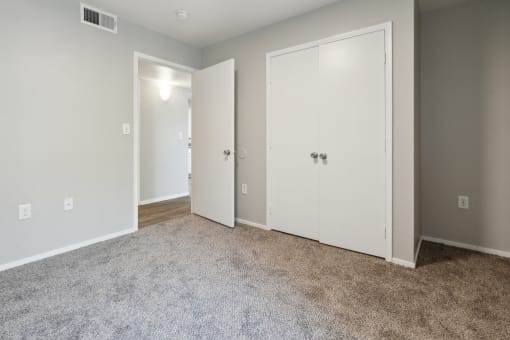 an empty room with white doors and a carpeted floor at Vista Linda, Santa Fe, NM