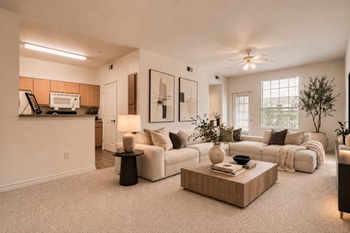 A living room with a white couch, a coffee table, and a ceiling fan.