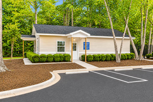 A small building with a parking lot in front of it.