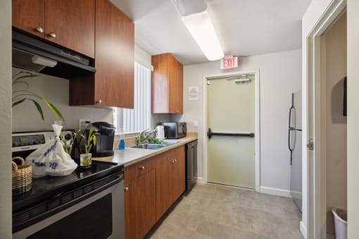 a kitchen with a refrigerator and sink and an exit door