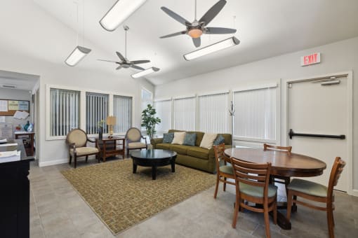 an open living room and dining room with a table and ceiling fans