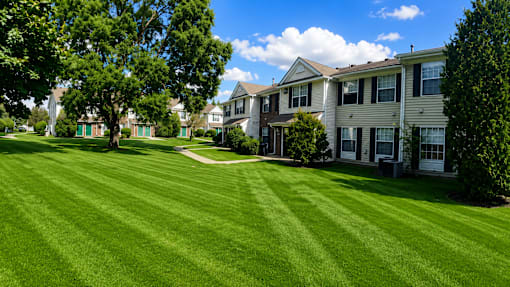 A row of houses with green lawns in front.