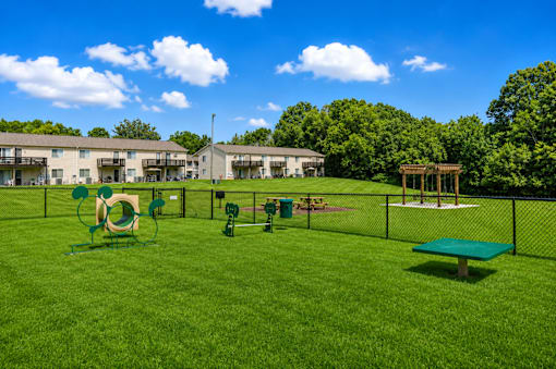 A playground area with a green slide, a green bench, and a green trampoline.