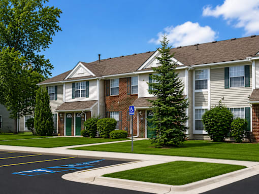 A residential building with a handicap parking sign in front.