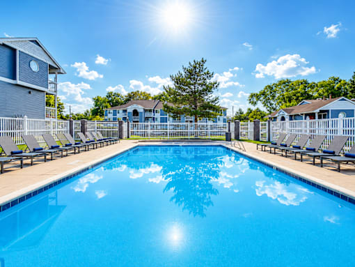 Outdoor swimming pool with lounge chairs at Creekview Apartments, Midvale, Utah