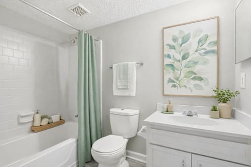 A white bathroom with a green shower curtain and a white toilet.