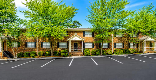 Brick apartment buildings with parking area at Stratford Arms Apartments, Riverdale, GA 30274