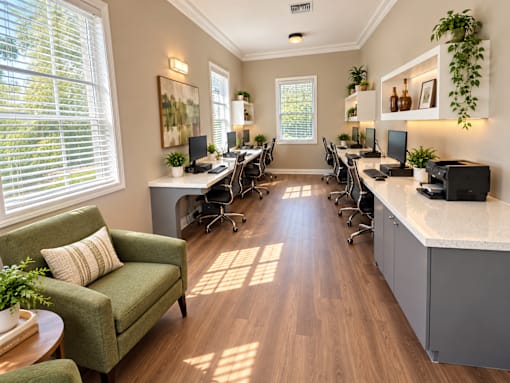 A sunny room with a green chair and a desk with a laptop on it.