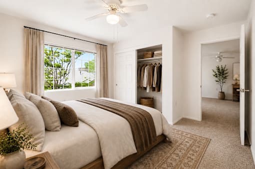 A bedroom with a large bed and a ceiling fan.