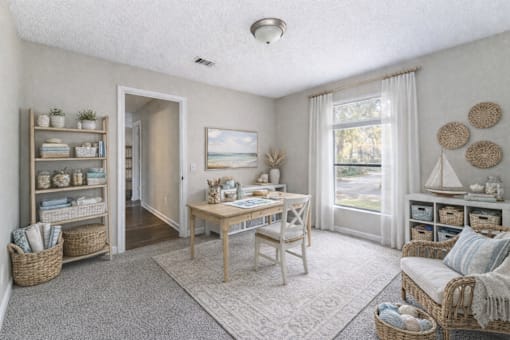 A cozy living room with a wooden table and chairs, a window with curtains, and a view of the outdoors. at Parkland at Orange Park Apartments , Florida, 32073