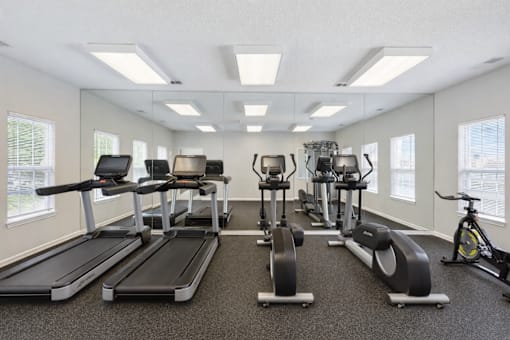 A spacious gym with treadmills, exercise bikes, and other equipment.