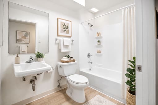 A white bathroom with a toilet, sink, and bathtub.