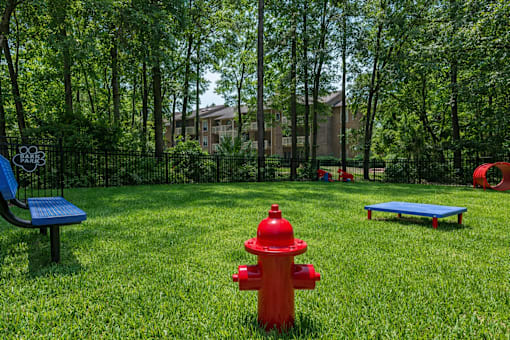 A red fire hydrant sits in the middle of a grassy area. at Parkland at Orange Park Apartments , Florida, 32073