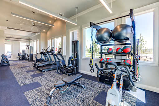 A gym with a variety of equipment including weights and machines.
