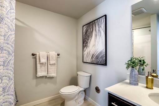 A white toilet sits in a bathroom next to a white sink.