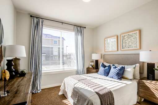 A bedroom with a large bed and two lamps.