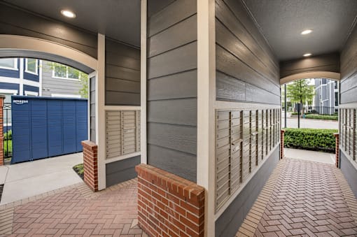A long hallway with brick floors and a brick pillar.