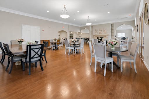 A large dining room with a wooden floor and white walls.