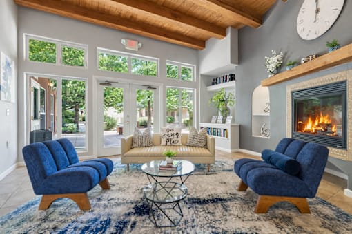 A living room with a fireplace and blue chairs.