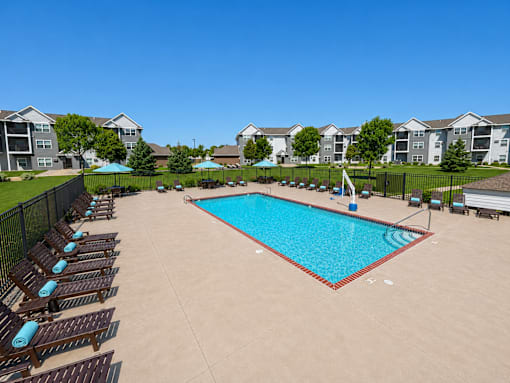 Resort style pool with lounge chairs and sundeck at Cypress Court Apartments, St Cloud, MN