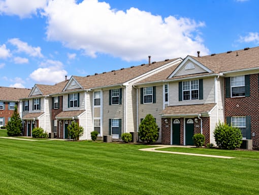 A row of houses with green lawns in front.