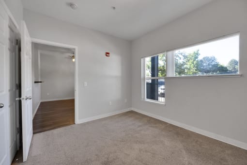 an empty living room with a large window and a door