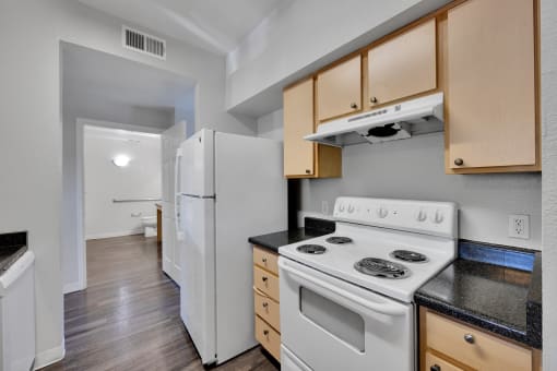 a kitchen with white appliances and wooden cabinets and a white refrigerator