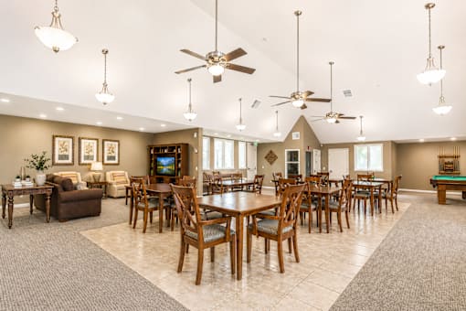 A spacious dining room with a large table and chairs.