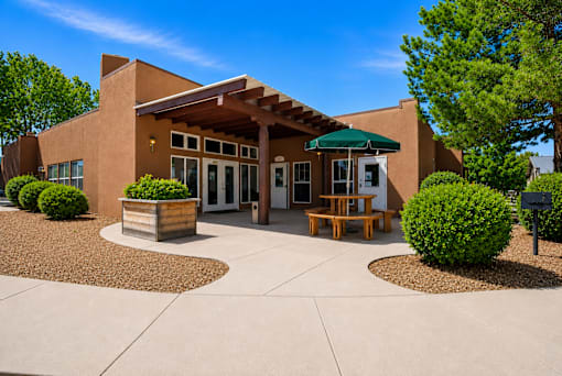 A building with a green awning and a bench in front of it.