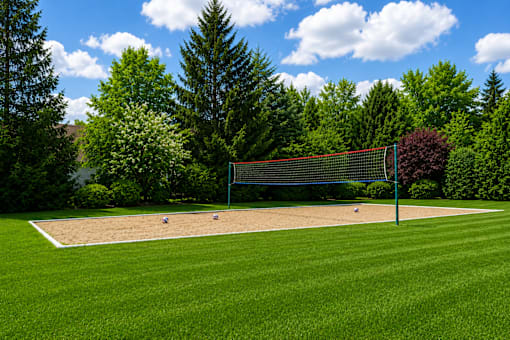A tennis court surrounded by trees and a blue sky.