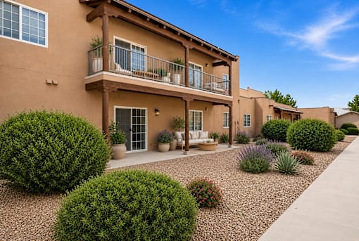 A row of houses with a gravel driveway and landscaping in front.